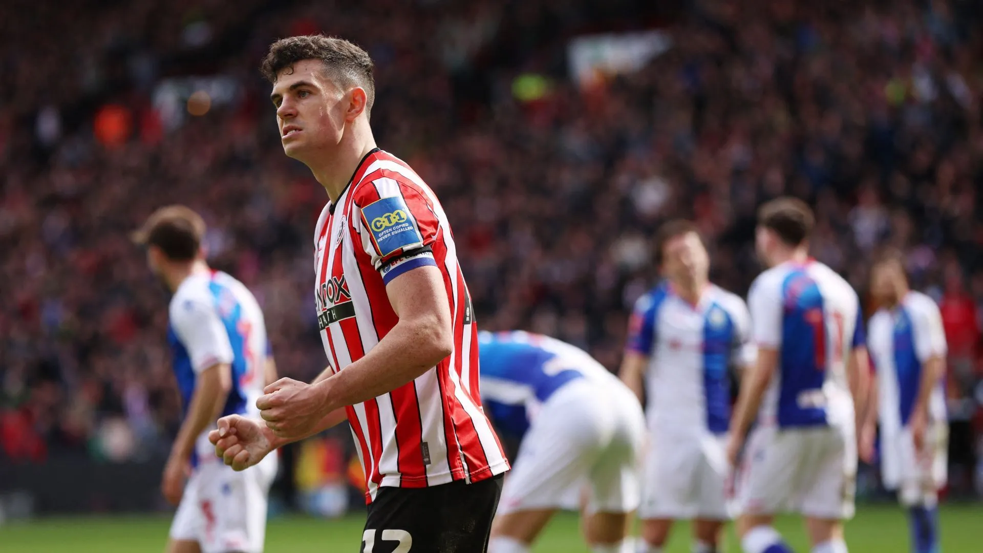 John Egan trong màu áo Sheffield United, thực hiện một pha tranh chấp bóng bổng